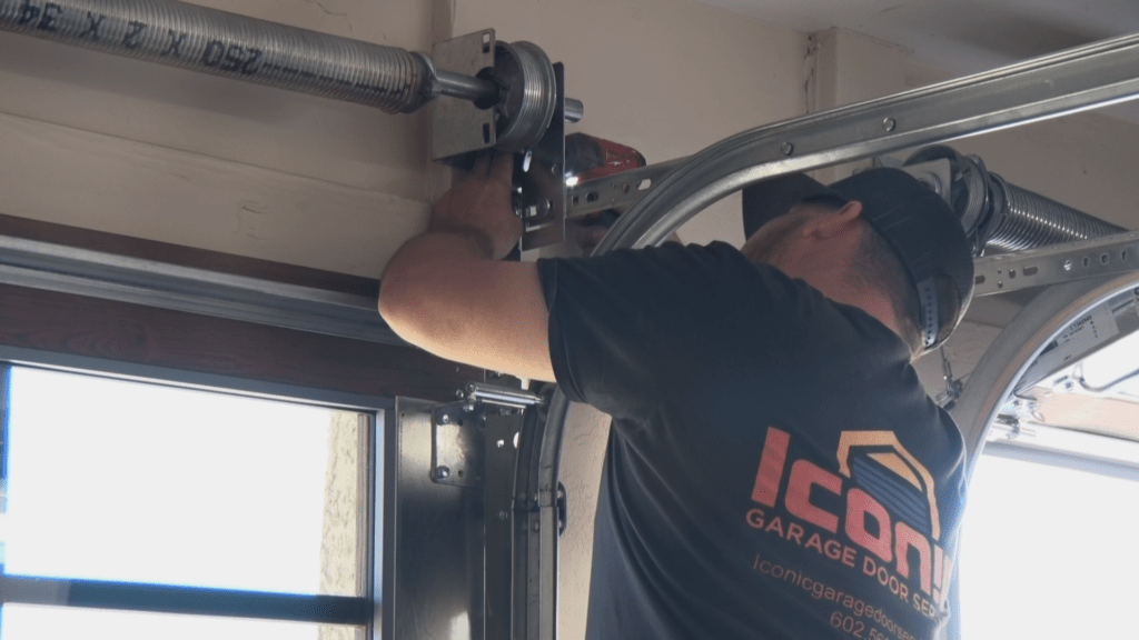 Iconic Garage Door Services repairman working on a garage door spring replacement 